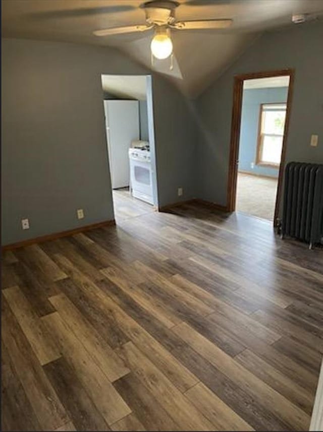 interior space featuring lofted ceiling, dark wood-type flooring, radiator heating unit, and ceiling fan