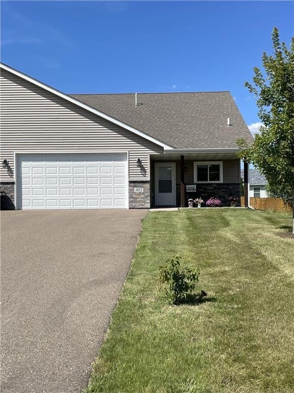 ranch-style house with a garage and a front lawn