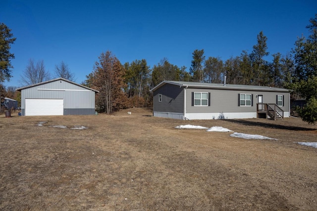 manufactured / mobile home featuring a garage, an outdoor structure, and a front lawn