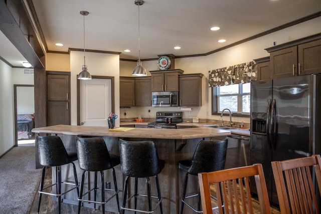 kitchen with butcher block countertops, decorative light fixtures, sink, a center island, and stainless steel appliances