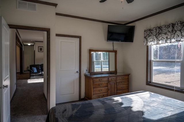 bedroom with crown molding, ceiling fan, and dark carpet