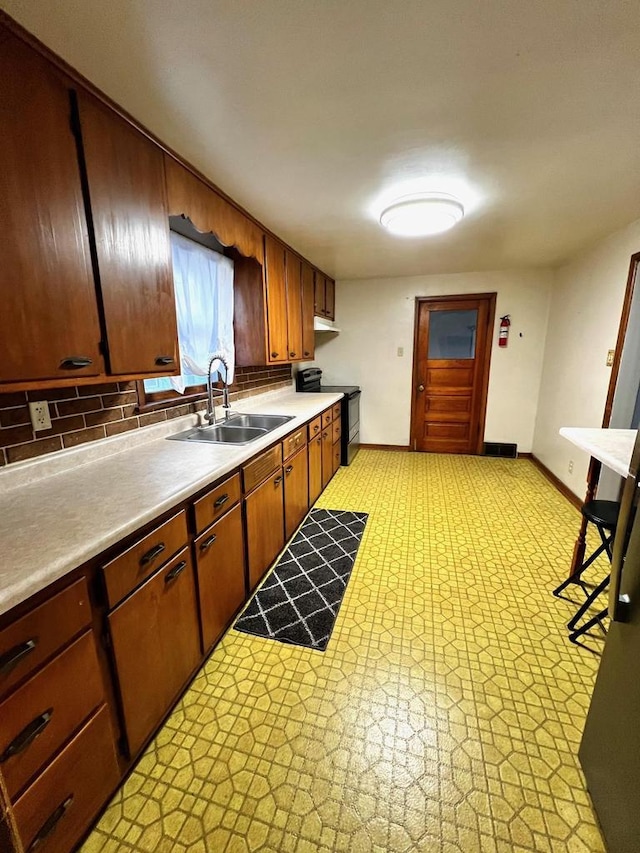 kitchen featuring sink, electric range, and decorative backsplash