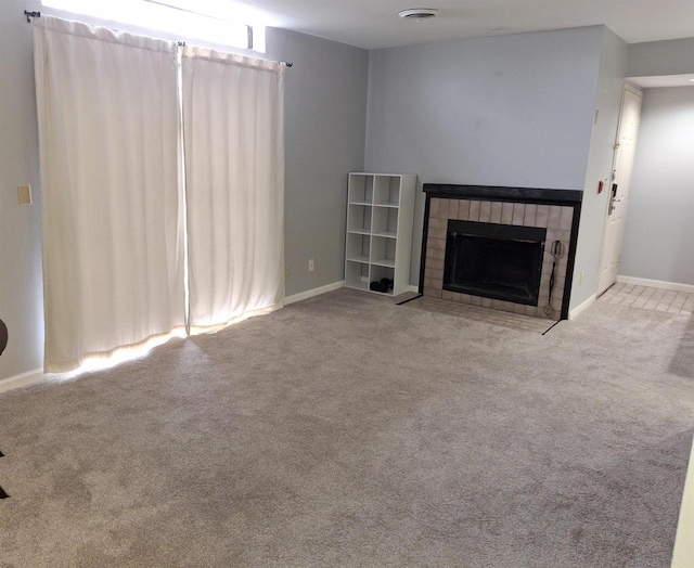 unfurnished living room with a tile fireplace and light carpet