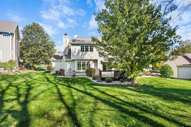 rear view of house featuring a lawn and a deck