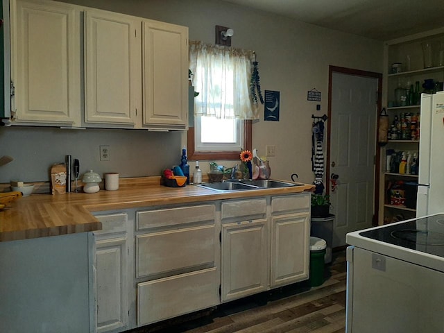 kitchen featuring dark hardwood / wood-style floors, butcher block countertops, white cabinetry, sink, and white appliances