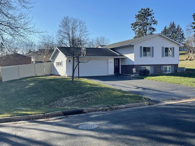 tri-level home with a garage and a front lawn