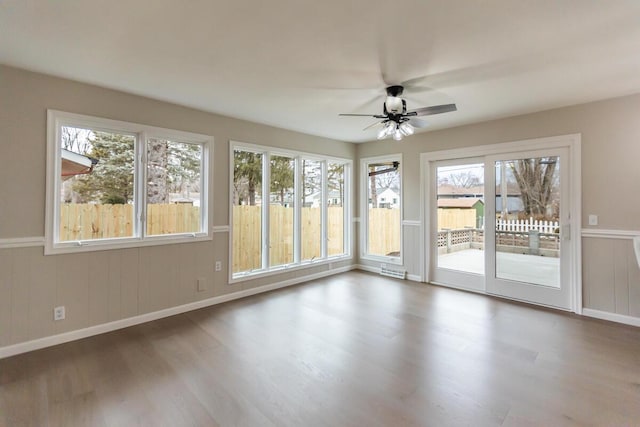 unfurnished sunroom with ceiling fan