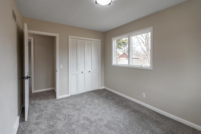 unfurnished bedroom with light colored carpet and a closet