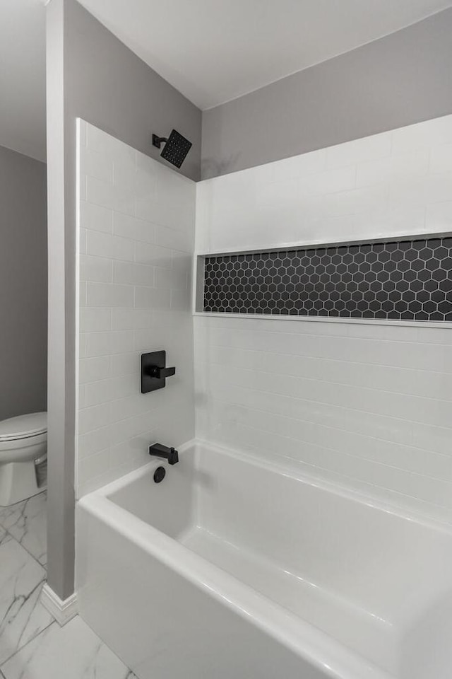 bathroom with tiled shower / bath combo and toilet