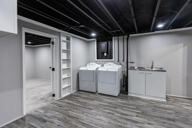 laundry room with sink, light hardwood / wood-style flooring, cabinets, and washing machine and clothes dryer