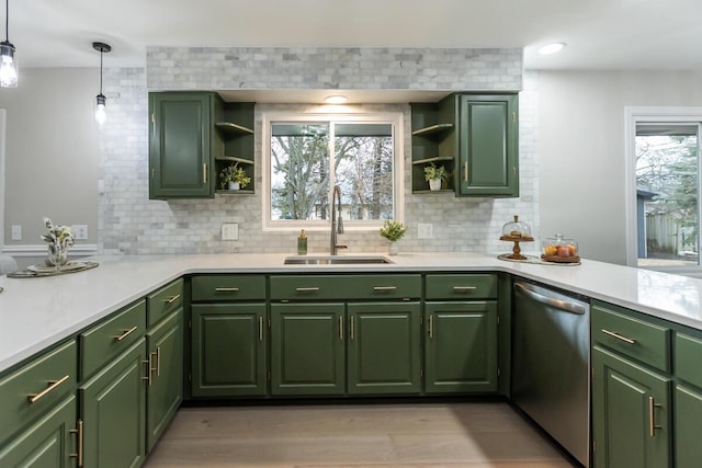 kitchen with tasteful backsplash, dishwasher, sink, hanging light fixtures, and green cabinets