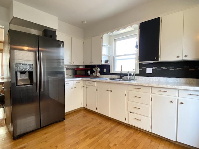 kitchen featuring white cabinets, sink, and stainless steel fridge