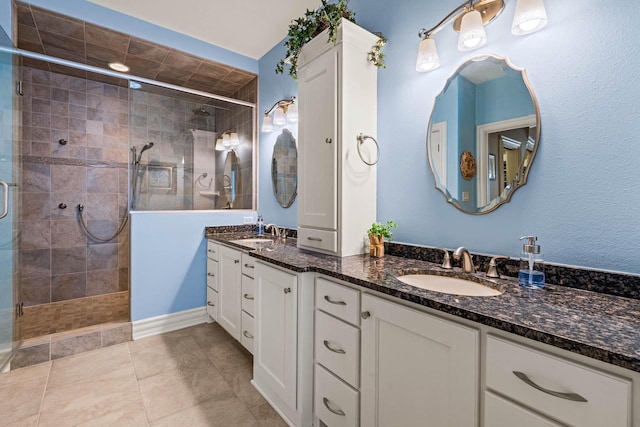 bathroom featuring tile patterned flooring, vanity, and walk in shower