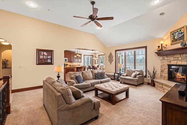 living room featuring light carpet, a fireplace, a wealth of natural light, and vaulted ceiling