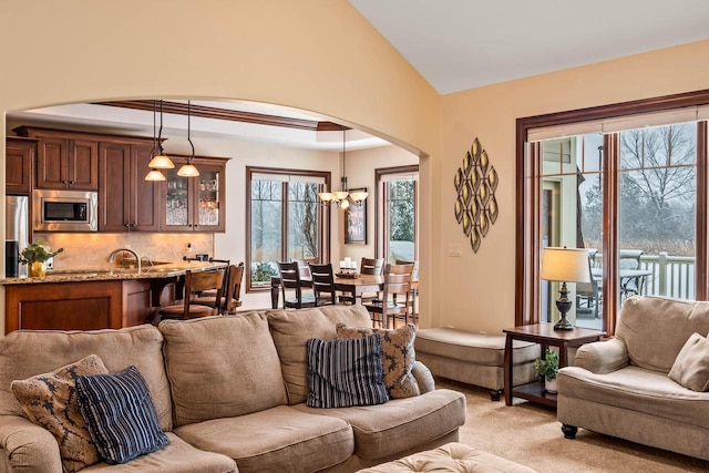 carpeted living room featuring an inviting chandelier