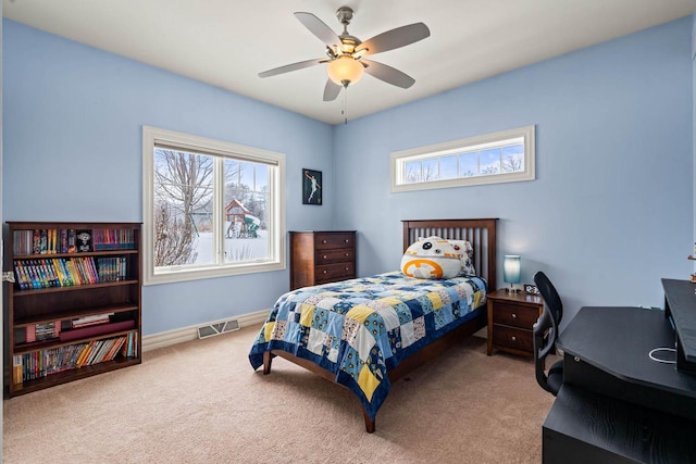 carpeted bedroom featuring multiple windows and ceiling fan