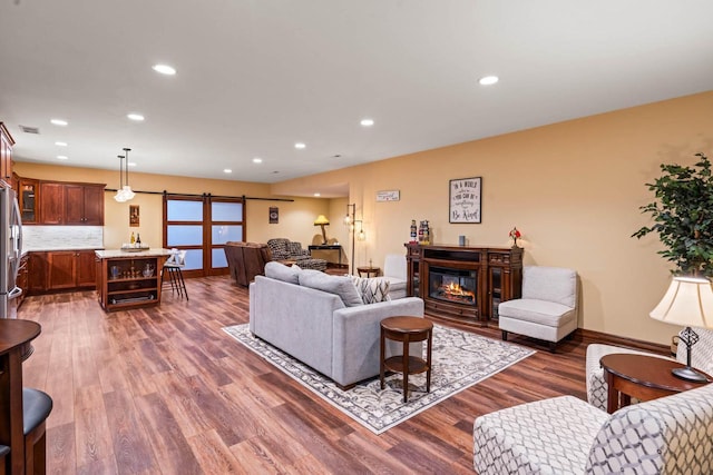 living room featuring a barn door and dark wood-type flooring