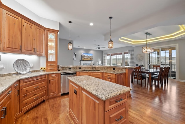 kitchen with sink, dishwasher, a kitchen island, decorative light fixtures, and kitchen peninsula