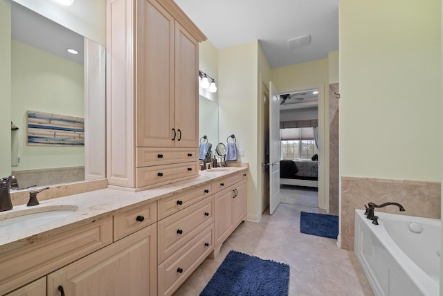 bathroom featuring tile patterned floors, vanity, and a washtub