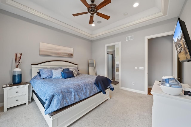 carpeted bedroom featuring connected bathroom, a raised ceiling, and ceiling fan