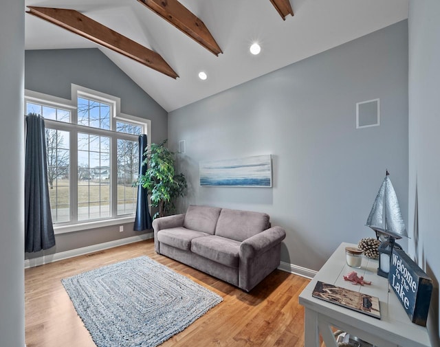 living room with beamed ceiling, hardwood / wood-style flooring, and high vaulted ceiling