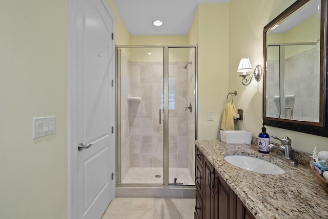 bathroom featuring tile patterned floors, vanity, and a shower with door