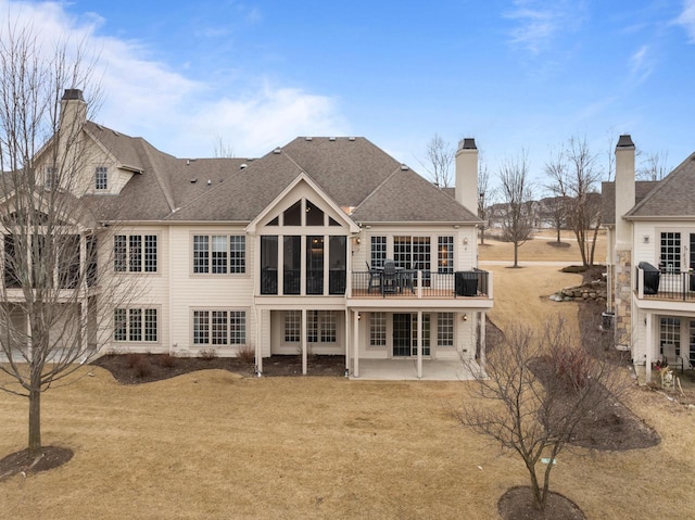 rear view of property featuring a lawn and a patio area