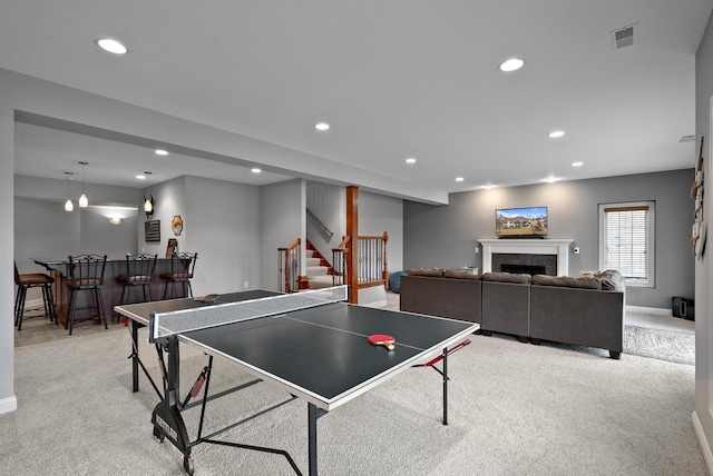 playroom with a premium fireplace, light carpet, and bar area