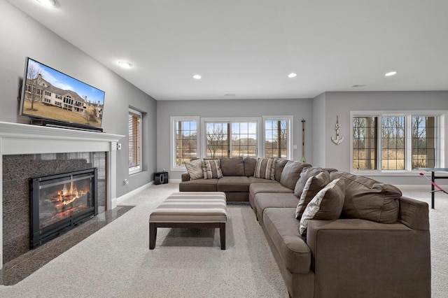 living room with light colored carpet, a healthy amount of sunlight, and a fireplace