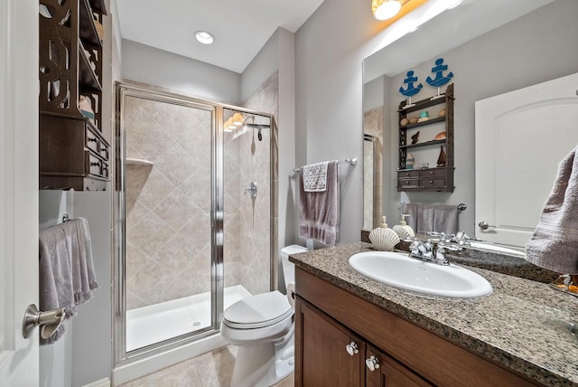 bathroom featuring vanity, a shower with shower door, tile patterned floors, and toilet