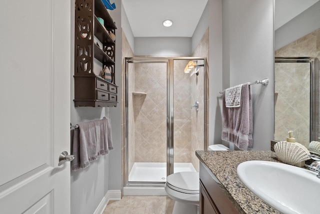 bathroom featuring a shower with door, vanity, tile patterned flooring, and toilet