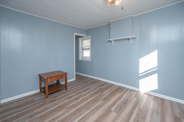 spare room featuring crown molding and light hardwood / wood-style floors