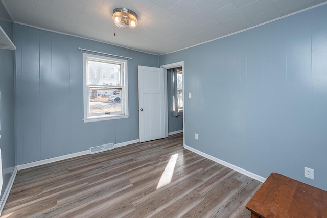 spare room featuring ornamental molding and hardwood / wood-style floors