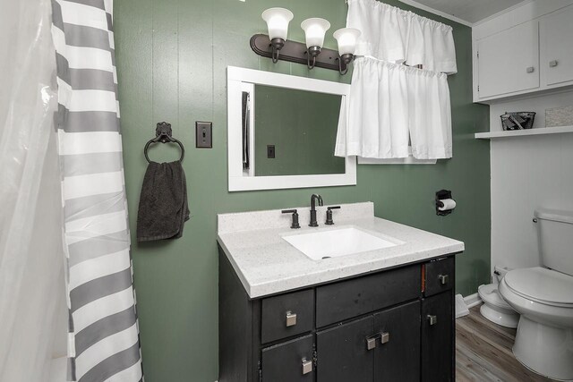 bathroom featuring wood-type flooring, vanity, and toilet