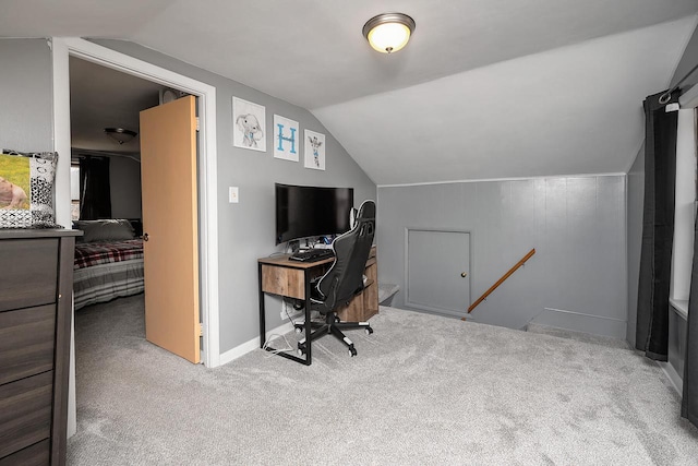 carpeted office space featuring vaulted ceiling