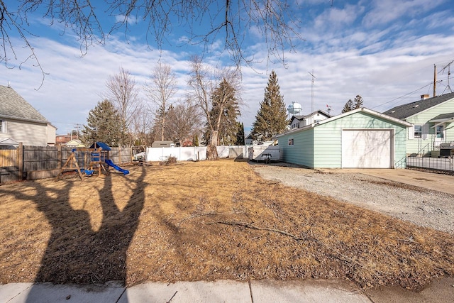 view of yard with an outbuilding, a garage, and a playground