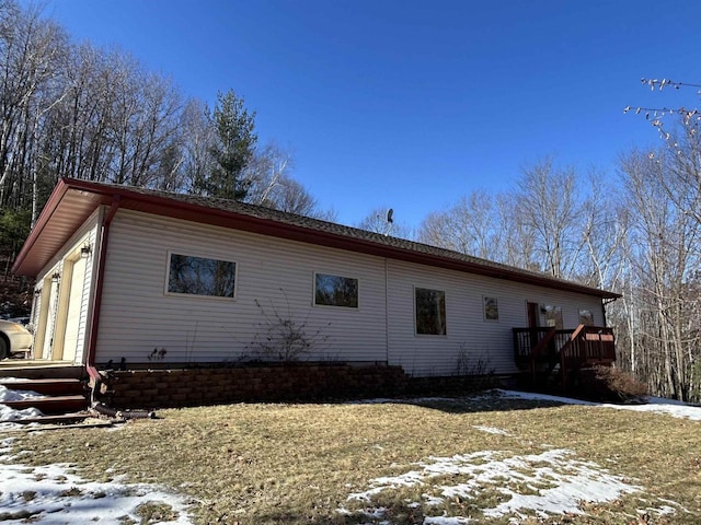 view of snow covered exterior featuring a wooden deck and an attached garage