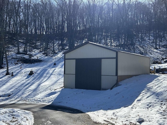 snow covered structure with a pole building and an outdoor structure