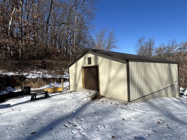 snow covered garage with a detached garage