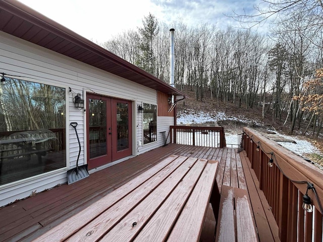 snow covered deck with french doors