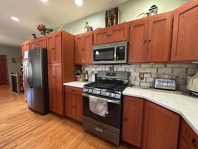 kitchen featuring recessed lighting, light wood-style floors, light countertops, appliances with stainless steel finishes, and tasteful backsplash