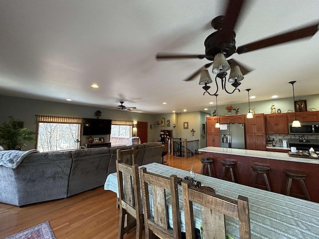 dining space with light wood-type flooring, ceiling fan, and recessed lighting