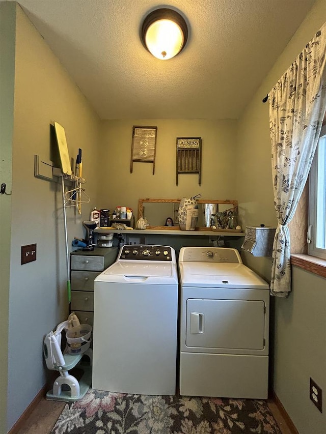 washroom featuring laundry area, a textured ceiling, baseboards, and separate washer and dryer