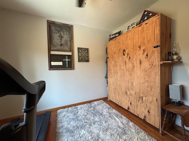 bedroom featuring baseboards and dark wood-type flooring