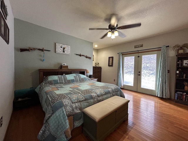 bedroom featuring french doors, a ceiling fan, a textured ceiling, wood finished floors, and access to outside