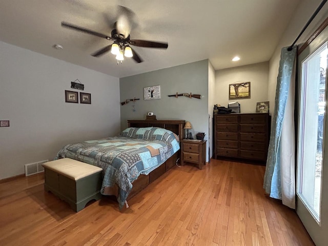 bedroom featuring light wood-style flooring, visible vents, and a ceiling fan