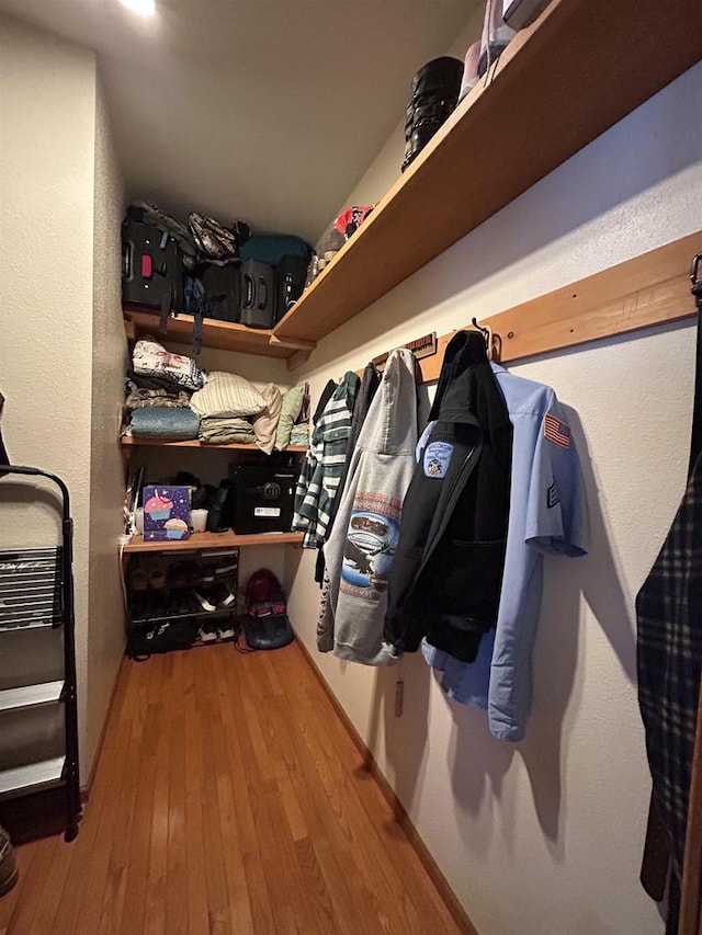 walk in closet with wood finished floors