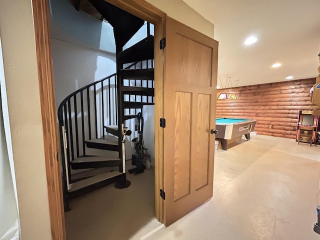 stairway with pool table, rustic walls, and recessed lighting