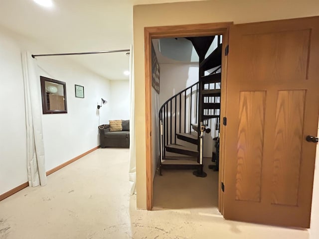 staircase featuring concrete floors and baseboards