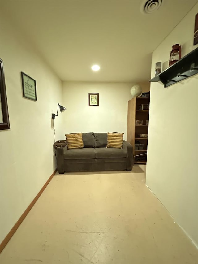 living area featuring concrete floors, visible vents, and baseboards